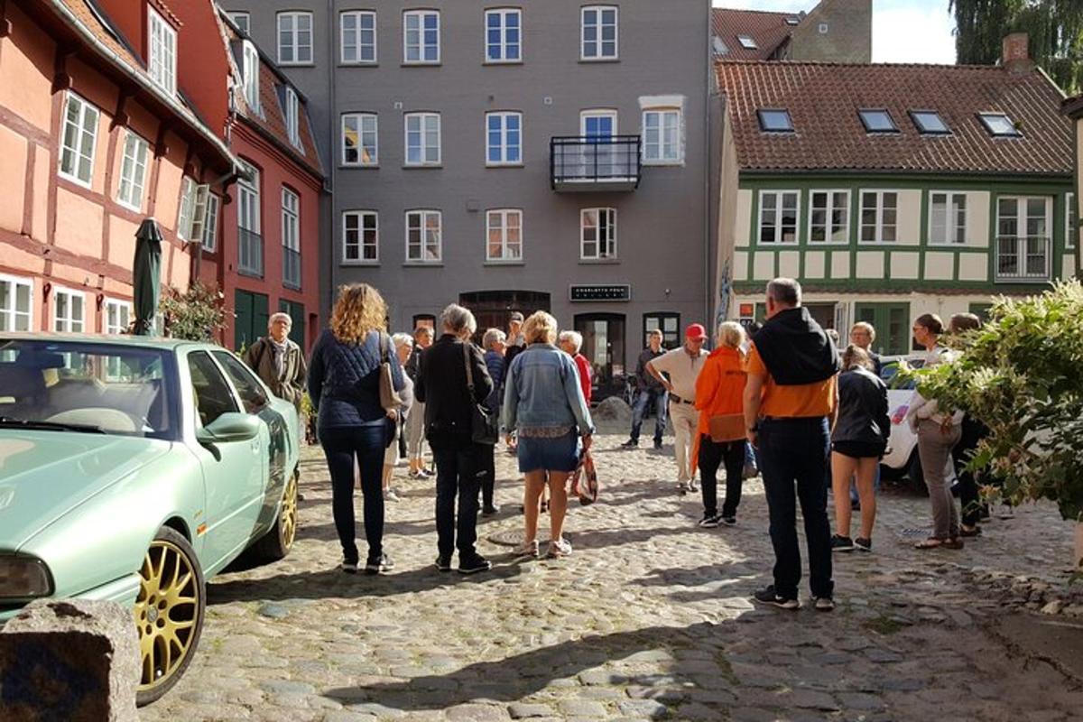 a group of people walking down a street with a car