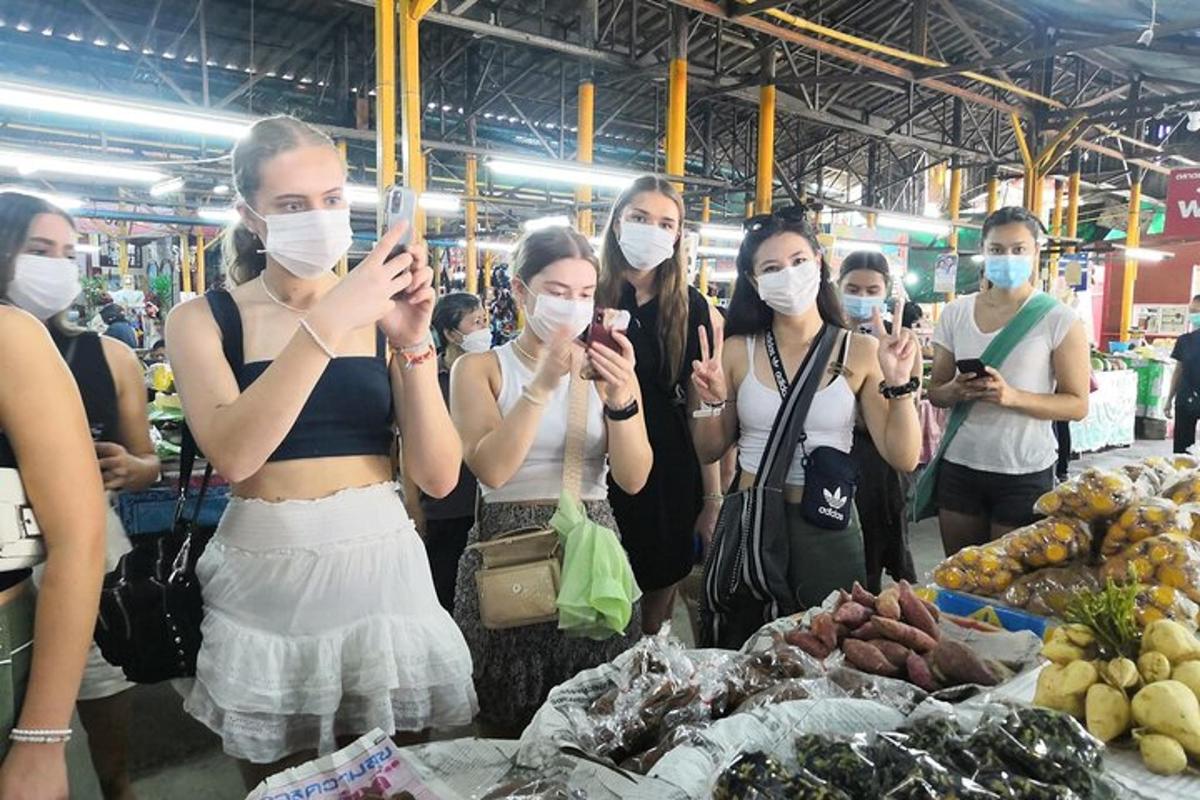 un gruppo di donne che indossano maschere facciali in un mercato