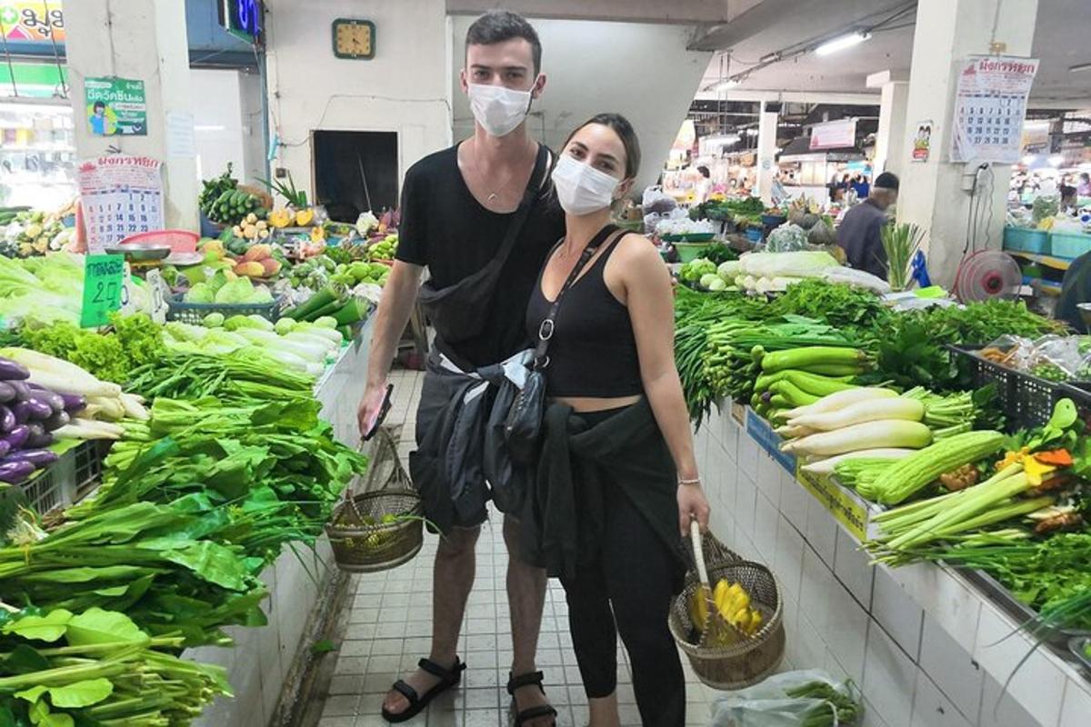 un uomo e una donna che indossano maschere facciali in un mercato