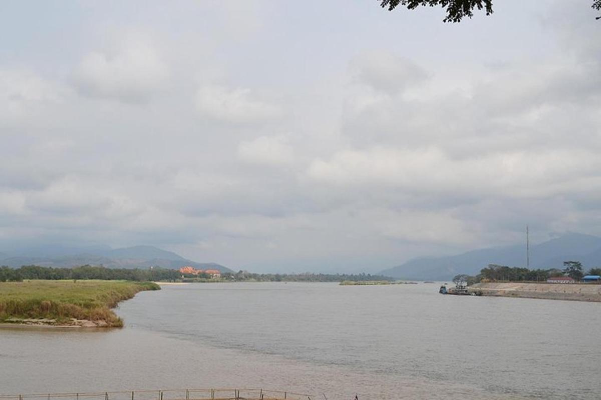 uma vista de um rio com montanhas ao fundo