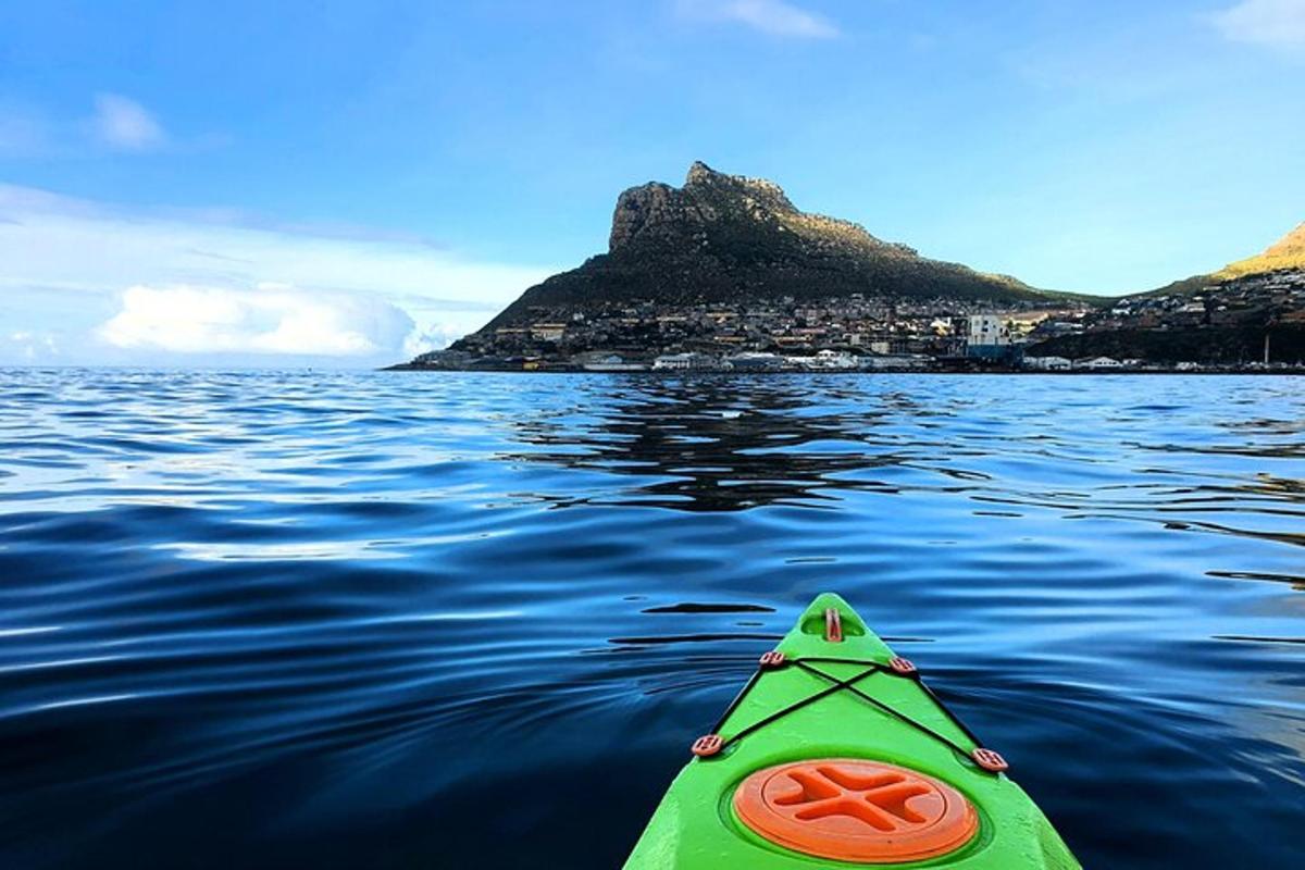 kayak hijau di dalam air dengan latar belakang pulau