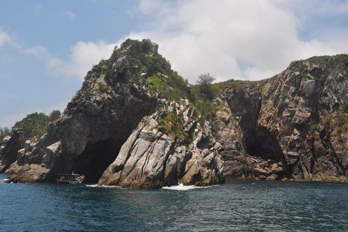 a boat in the water near a rocky island