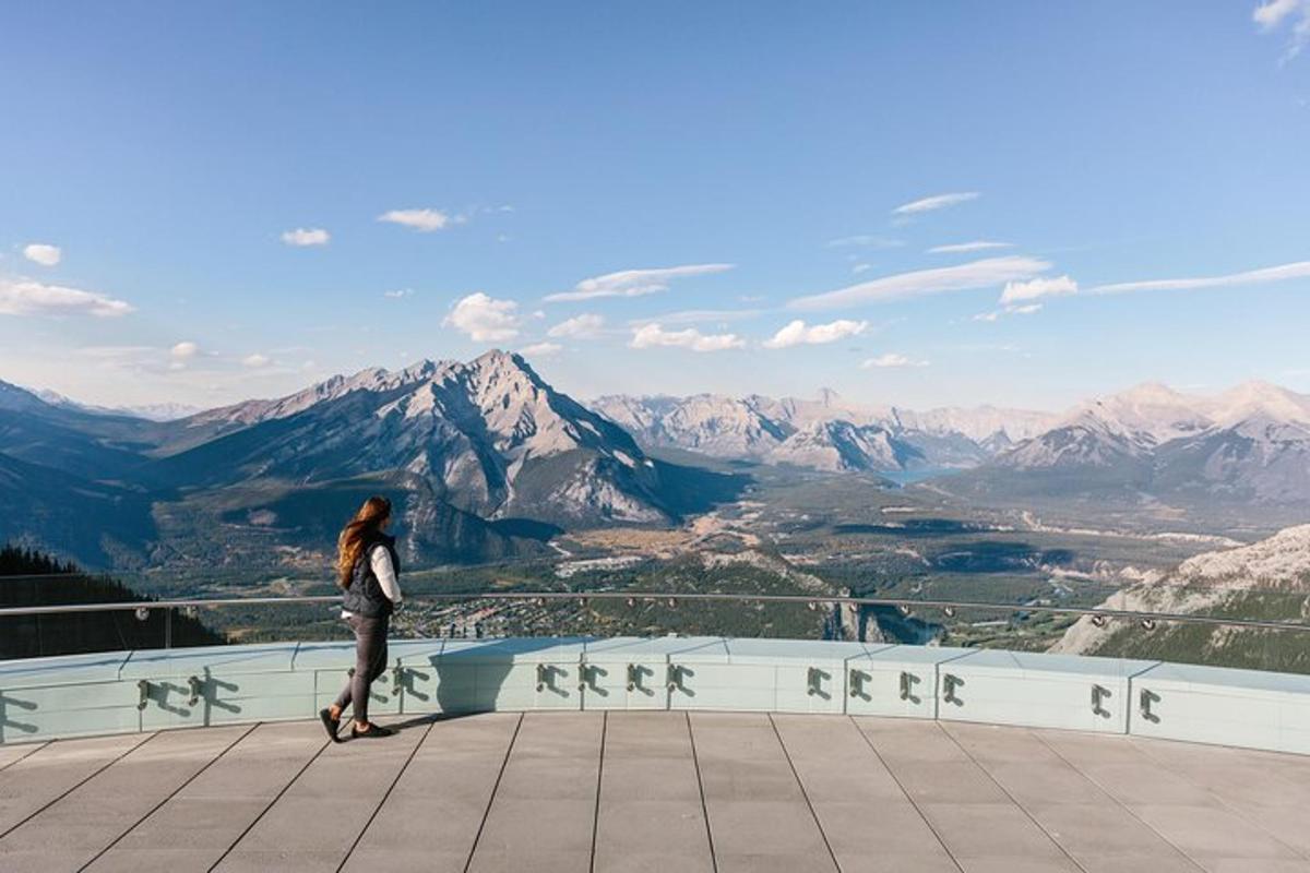 a woman walking on a ledge looking at the mountains
