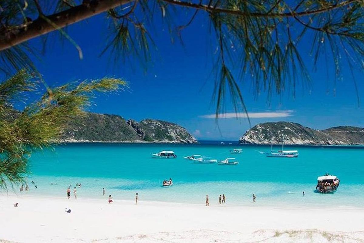 a group of people on a beach with boats in the water