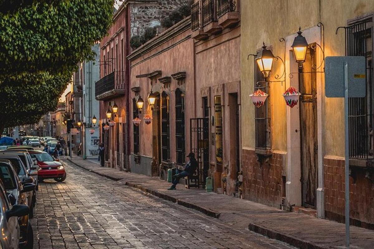 a person sitting on a bench on a cobblestone street