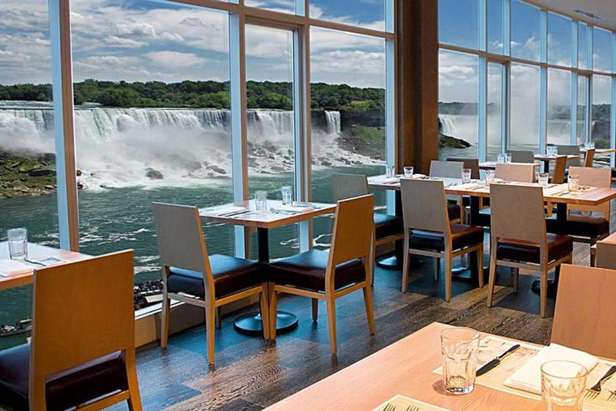 restaurace se stoly a židlemi a výhledem na vodopád