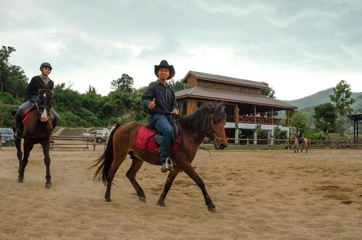 duas pessoas andando a cavalo em frente a um prédio