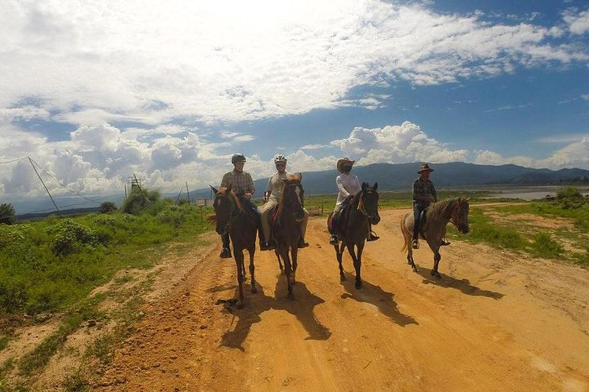 um grupo de pessoas andando a cavalo por uma estrada de terra