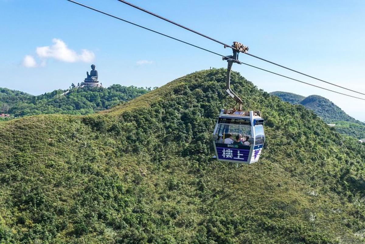 a cable car flying over a hill with a statue