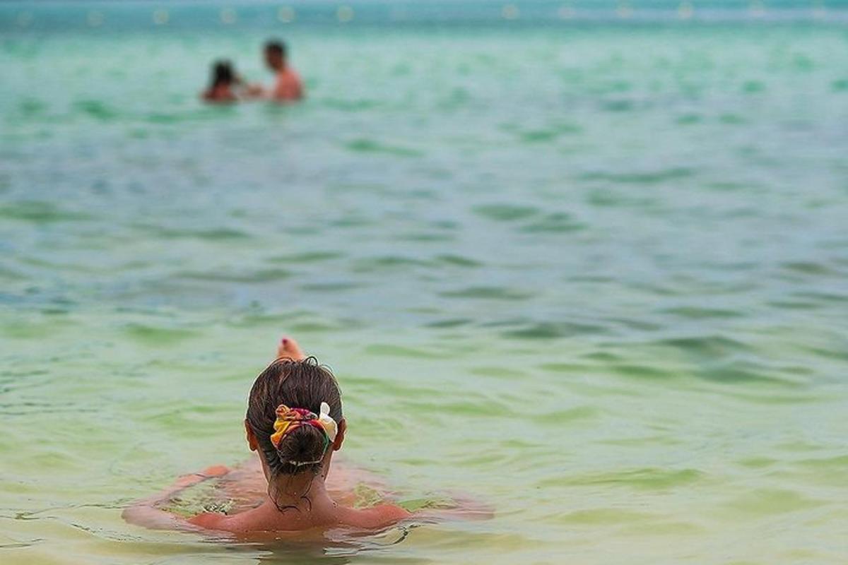 osoba plavající ve vodě na pláži