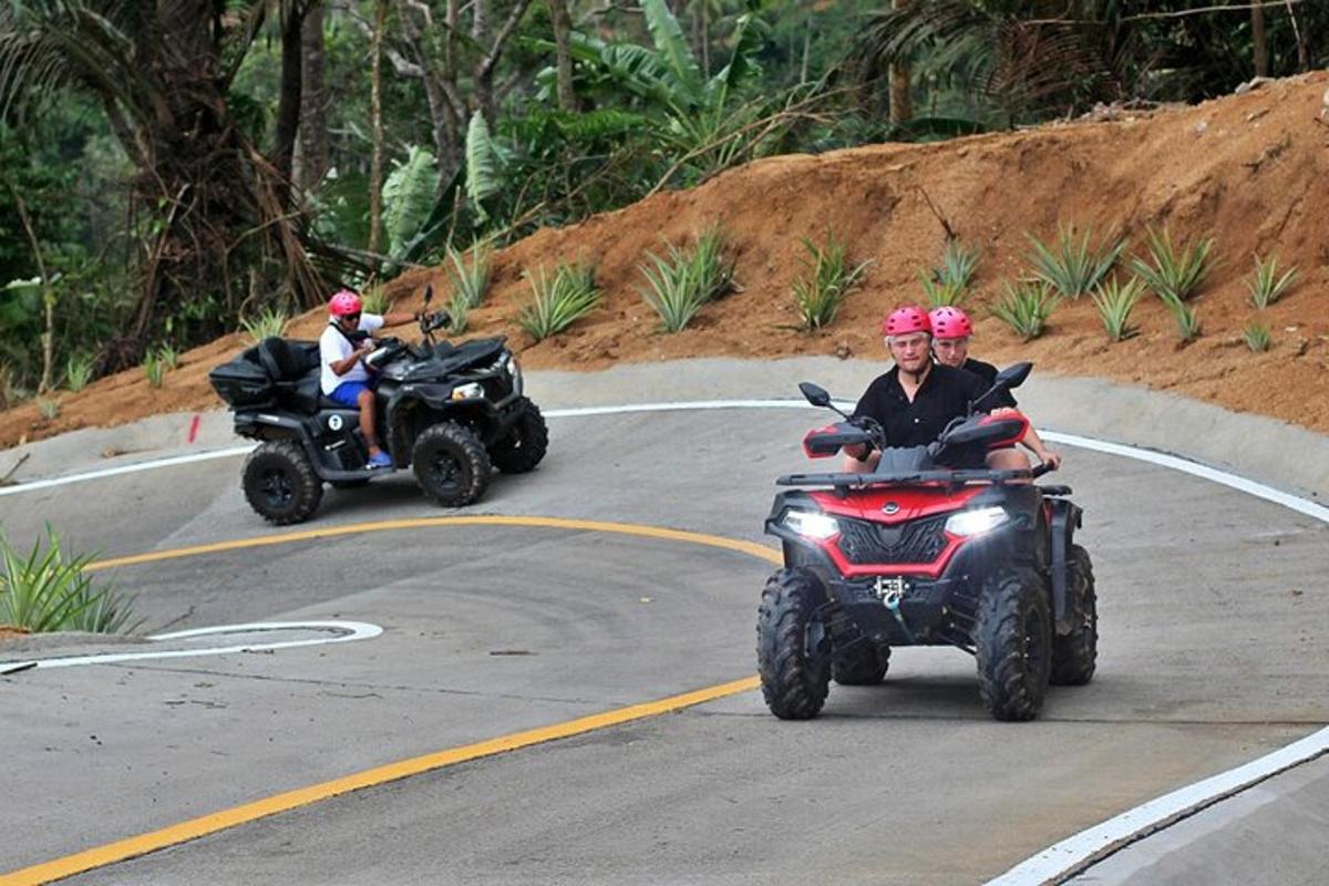 duas pessoas em quadriciclos dirigindo por uma estrada