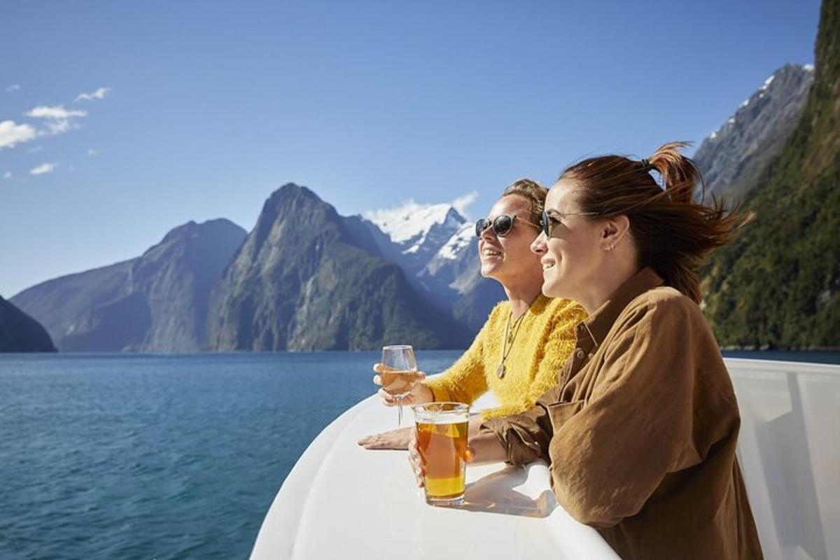 two women sitting on a boat with glasses of beer
