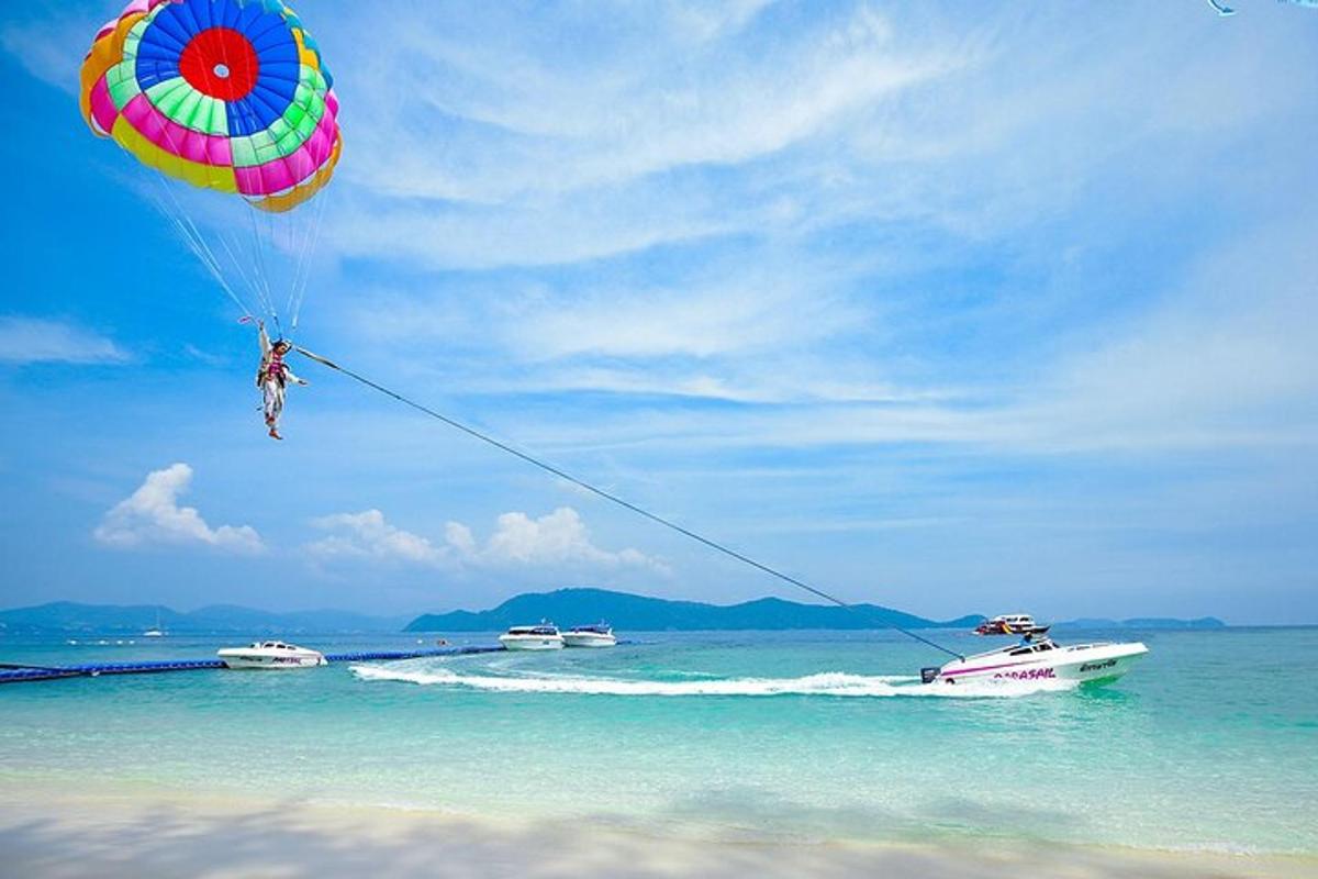 một người đang thả dù trên bãi biển cùng với những chiếc thuyền