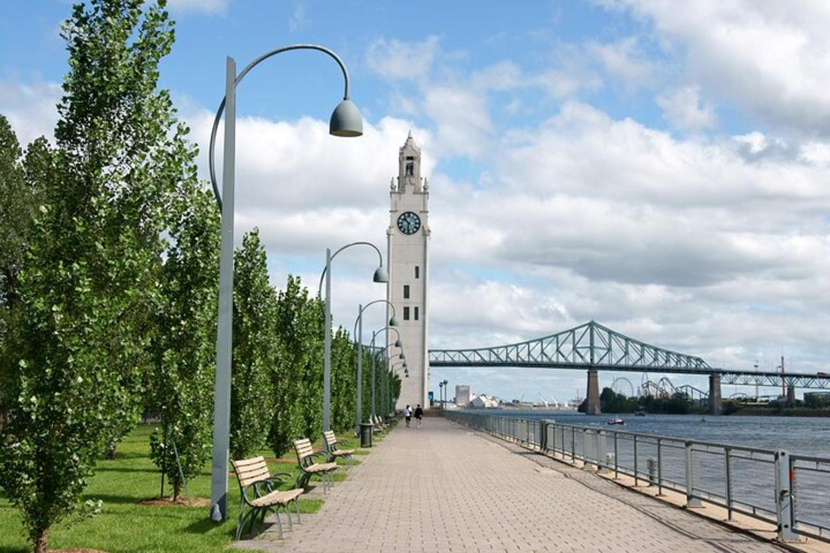 una torre dell'orologio accanto a un fiume con un ponte