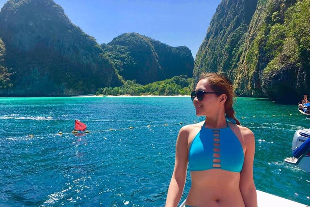 una donna in bikini in piedi su una barca in acqua