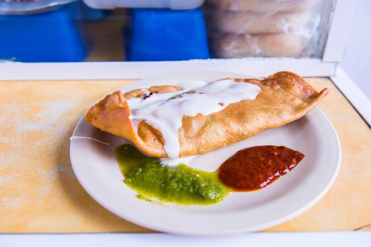 a plate of food with a pastry and a pickle