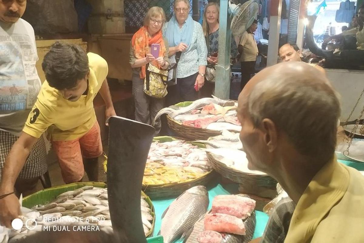 um grupo de pessoas em pé ao redor de uma mesa com comida