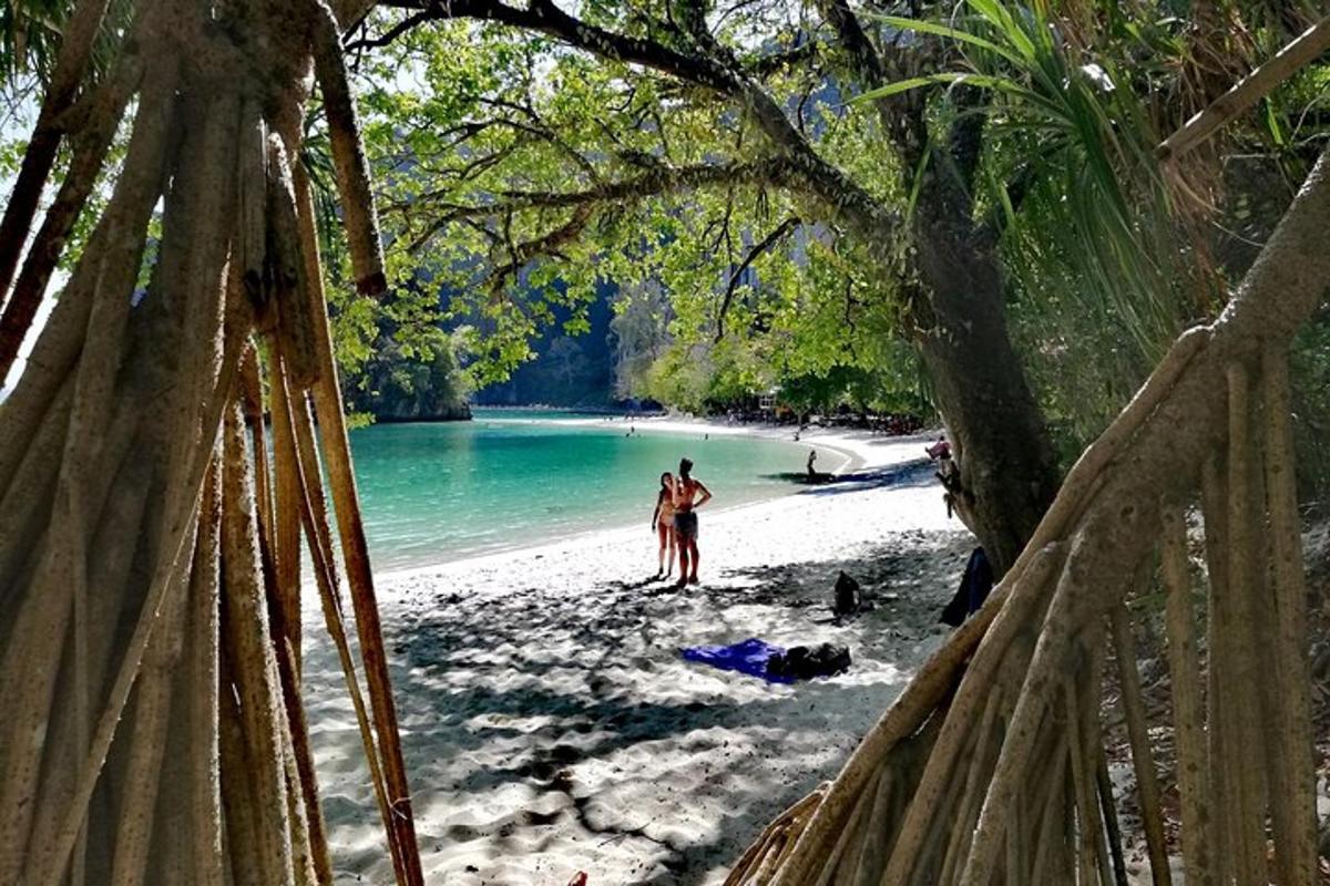 dua orang berdiri di pantai berhampiran air