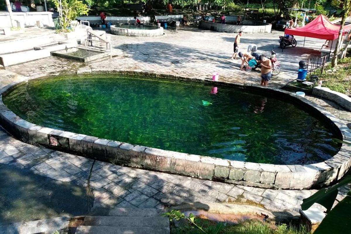 uma pequena piscina de água com pessoas em pé ao redor dela
