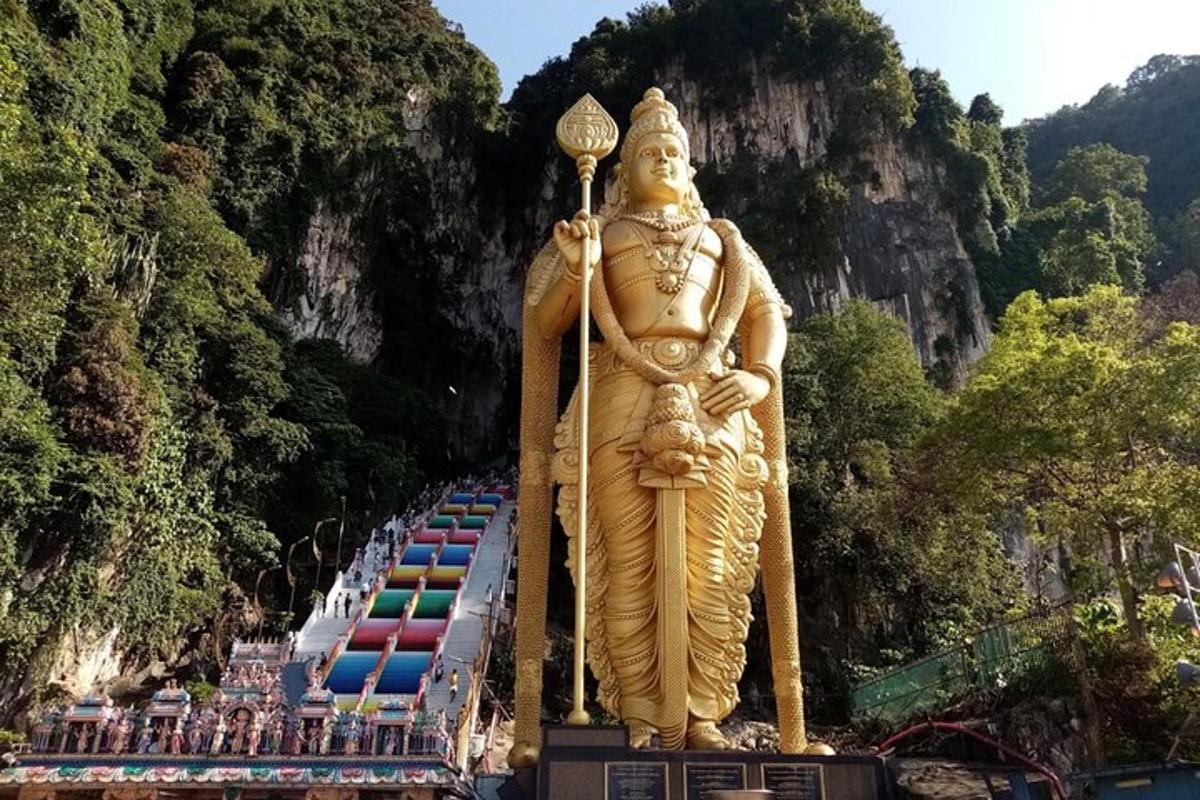 uma grande estátua de um deus em pé em frente a uma montanha