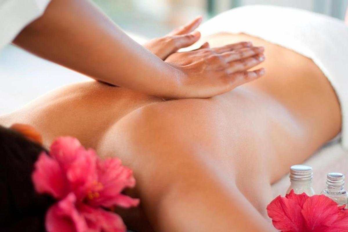 seorang wanita mendapatkan urutan di spa dengan bunga