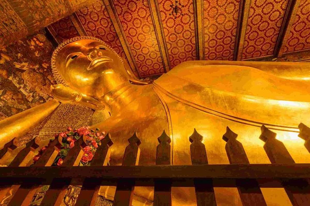 patung emas seorang Buddha yang duduk di sebelah piano