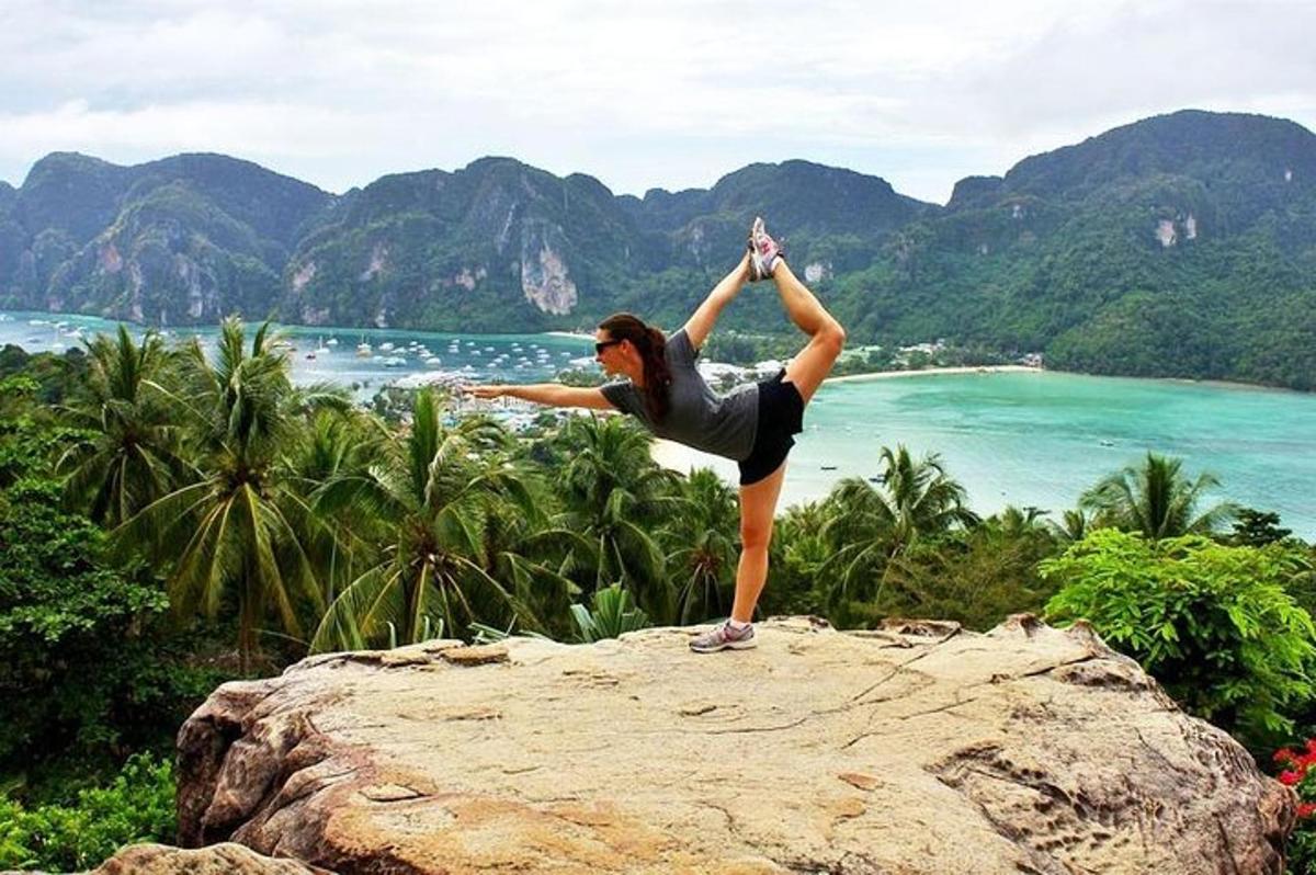 seorang wanita melakukan pose yoga di atas batu