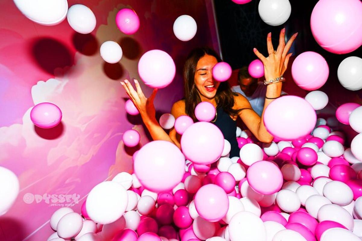 a woman standing in a pile of pink balls