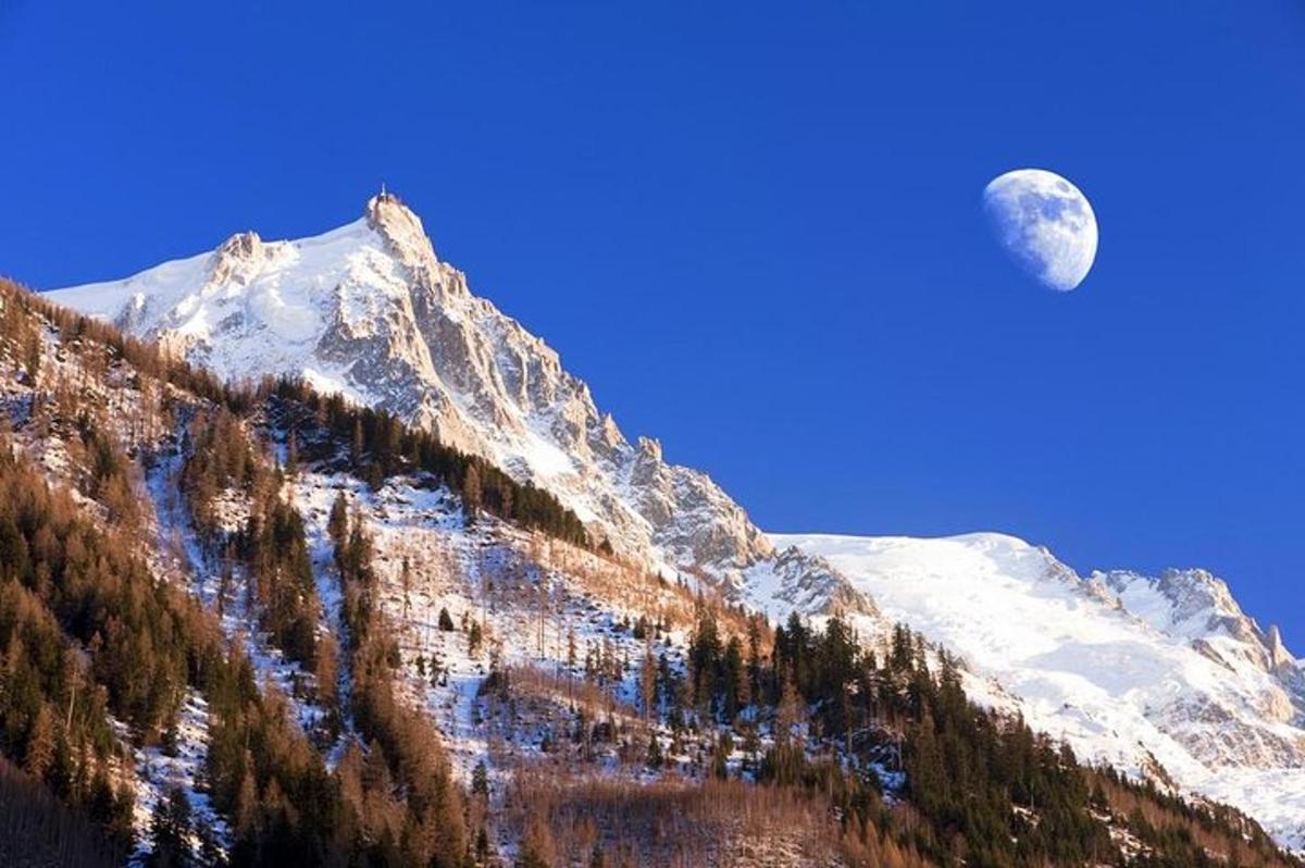 a moon on top of a snow covered mountain
