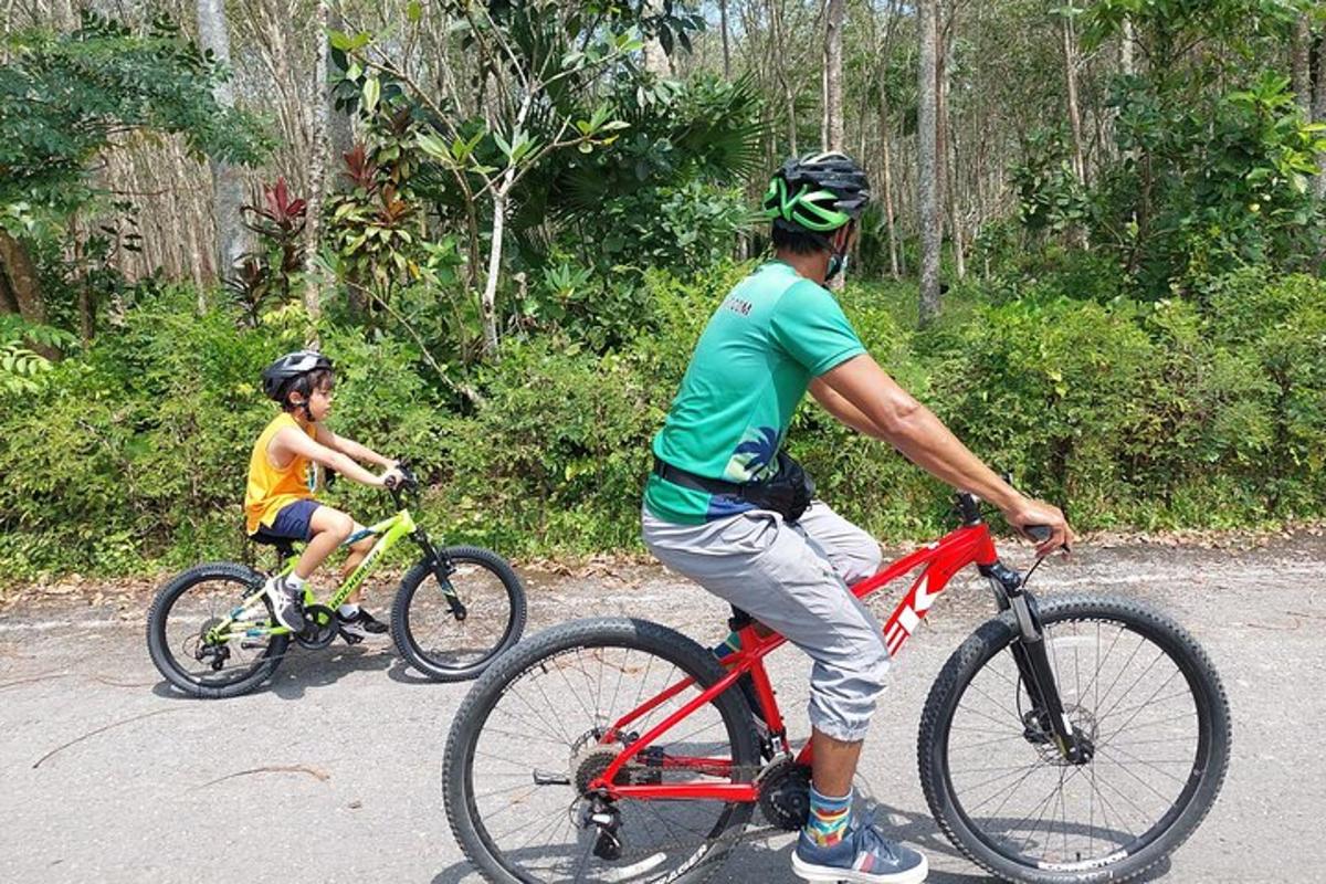 a man riding a red bike next to a boy