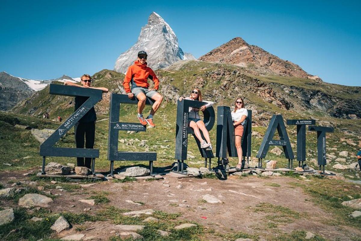 a group of people sitting on top of a sign with a mountain