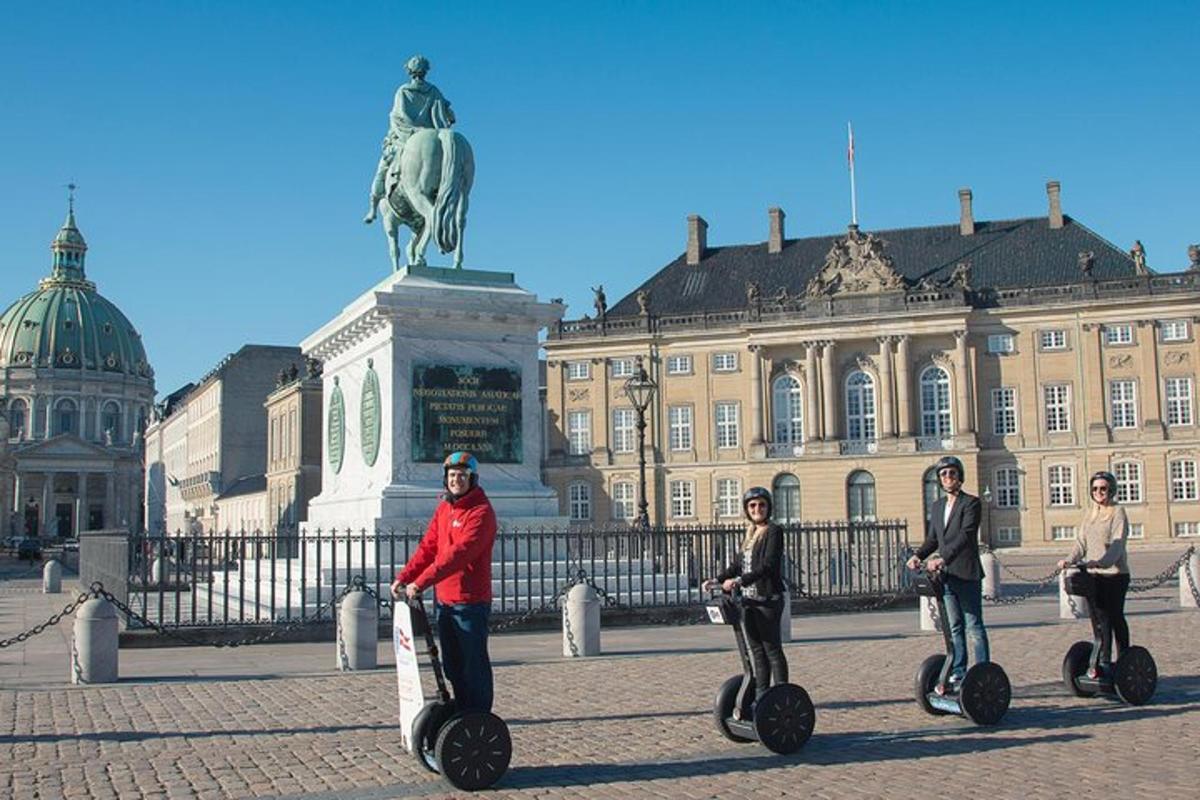 skupina lidí jedoucích na segwayích před budovou