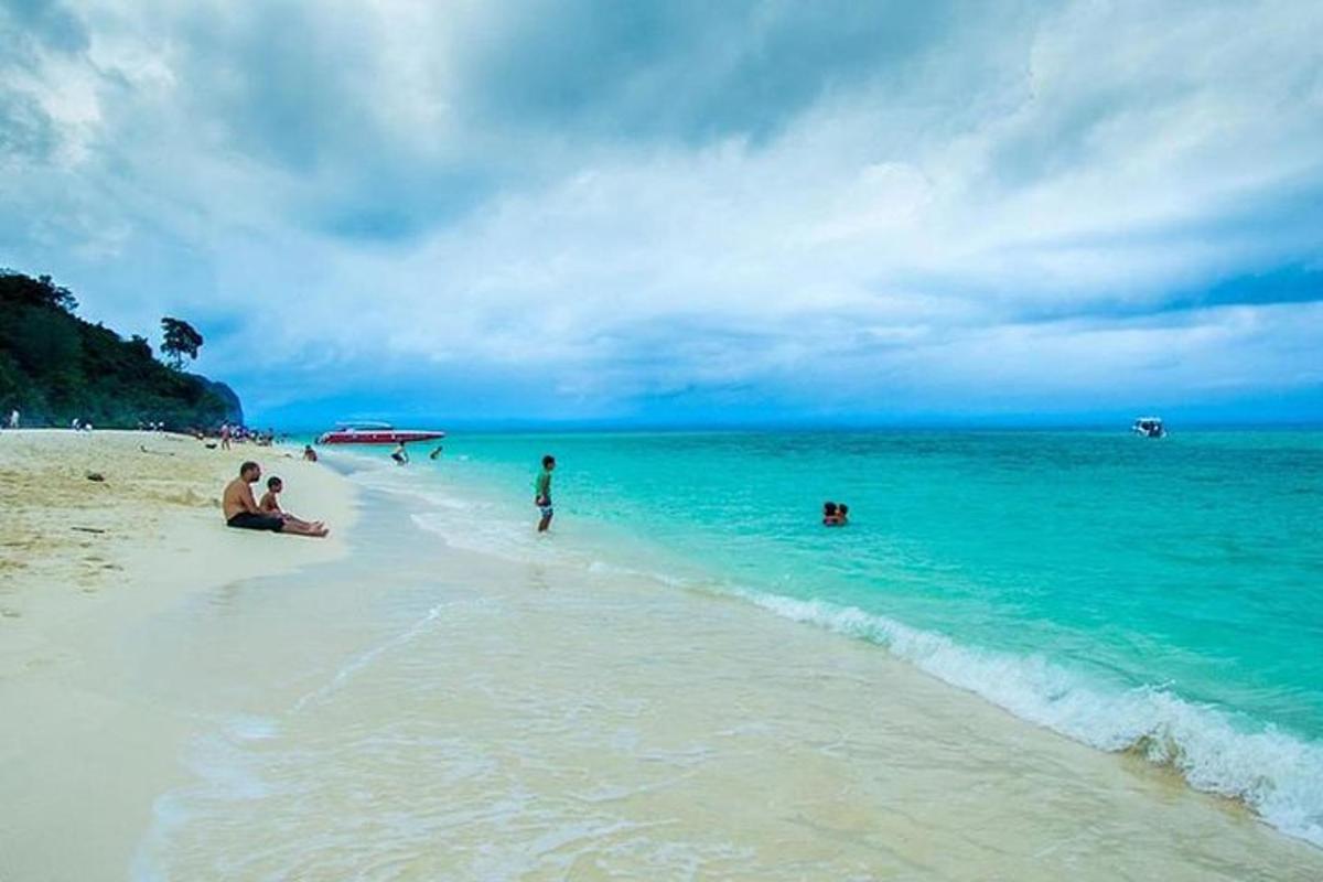 a group of people sitting on a beach with the ocean