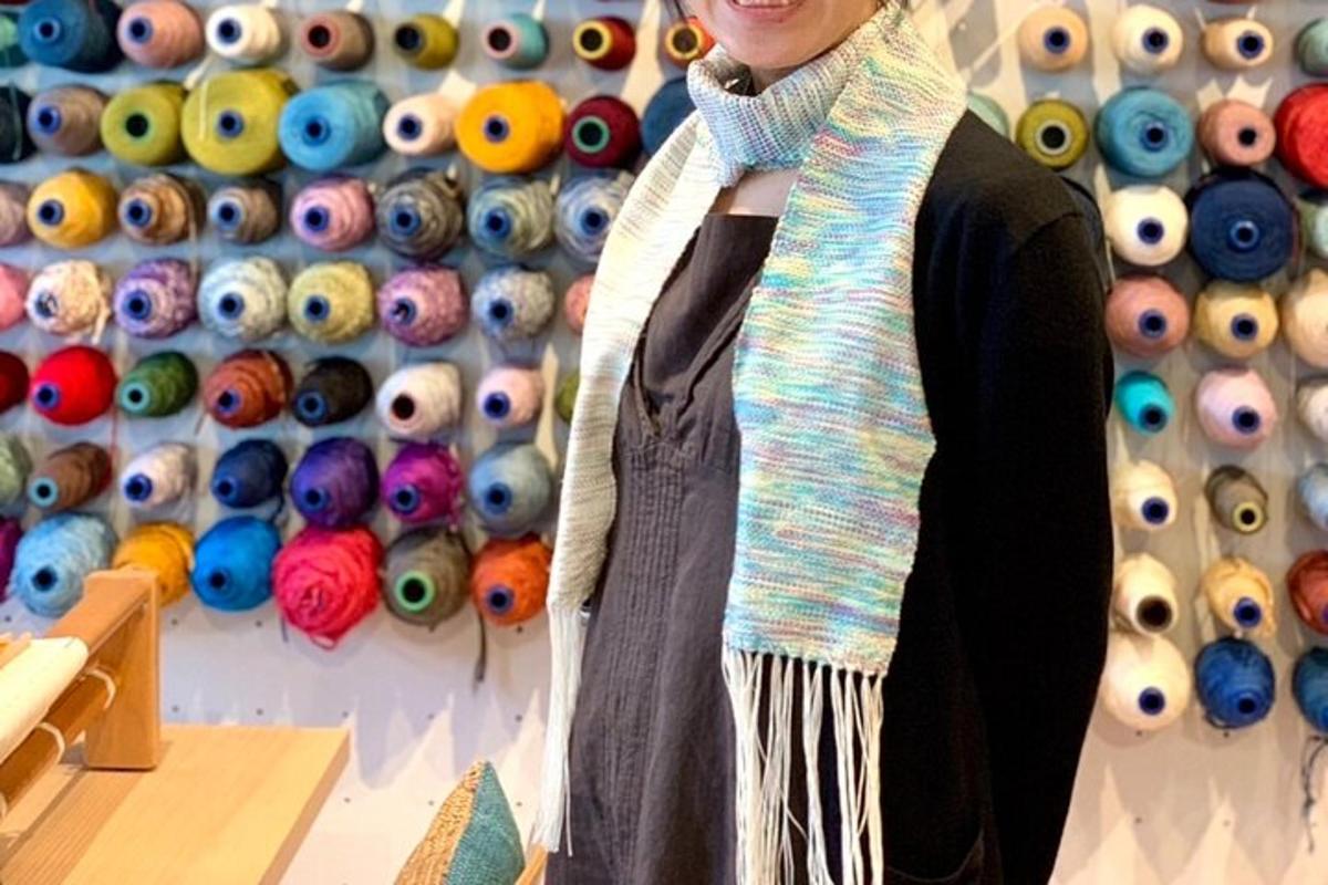 a woman is standing in front of a wall of eyes
