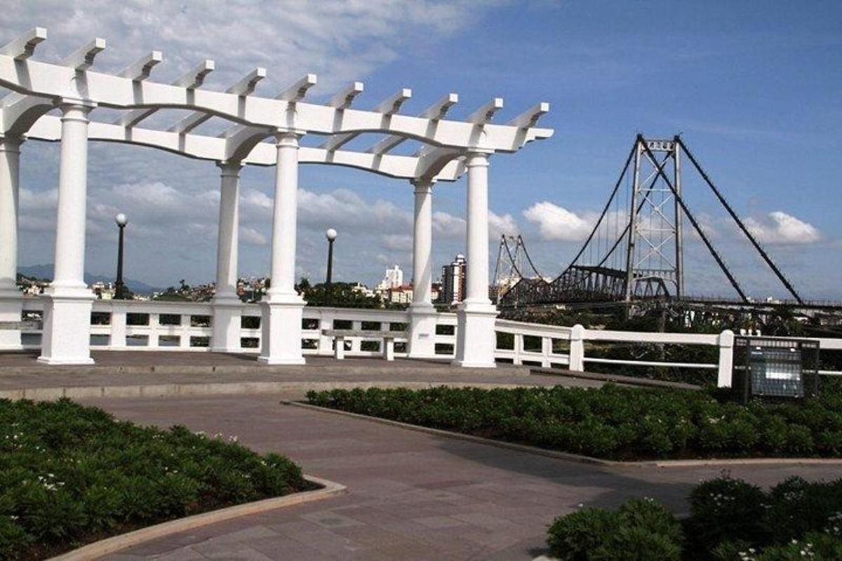 a large white pavilion with a bridge in the background