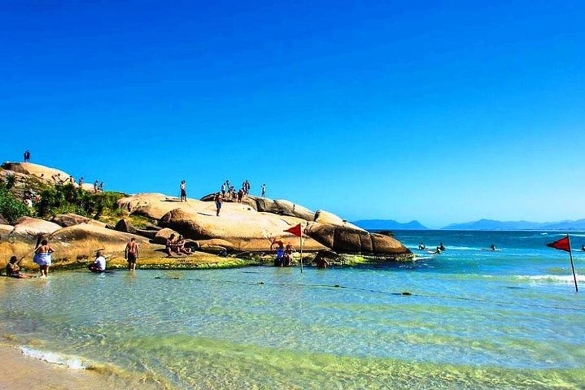 a group of people sitting on rocks on the beach