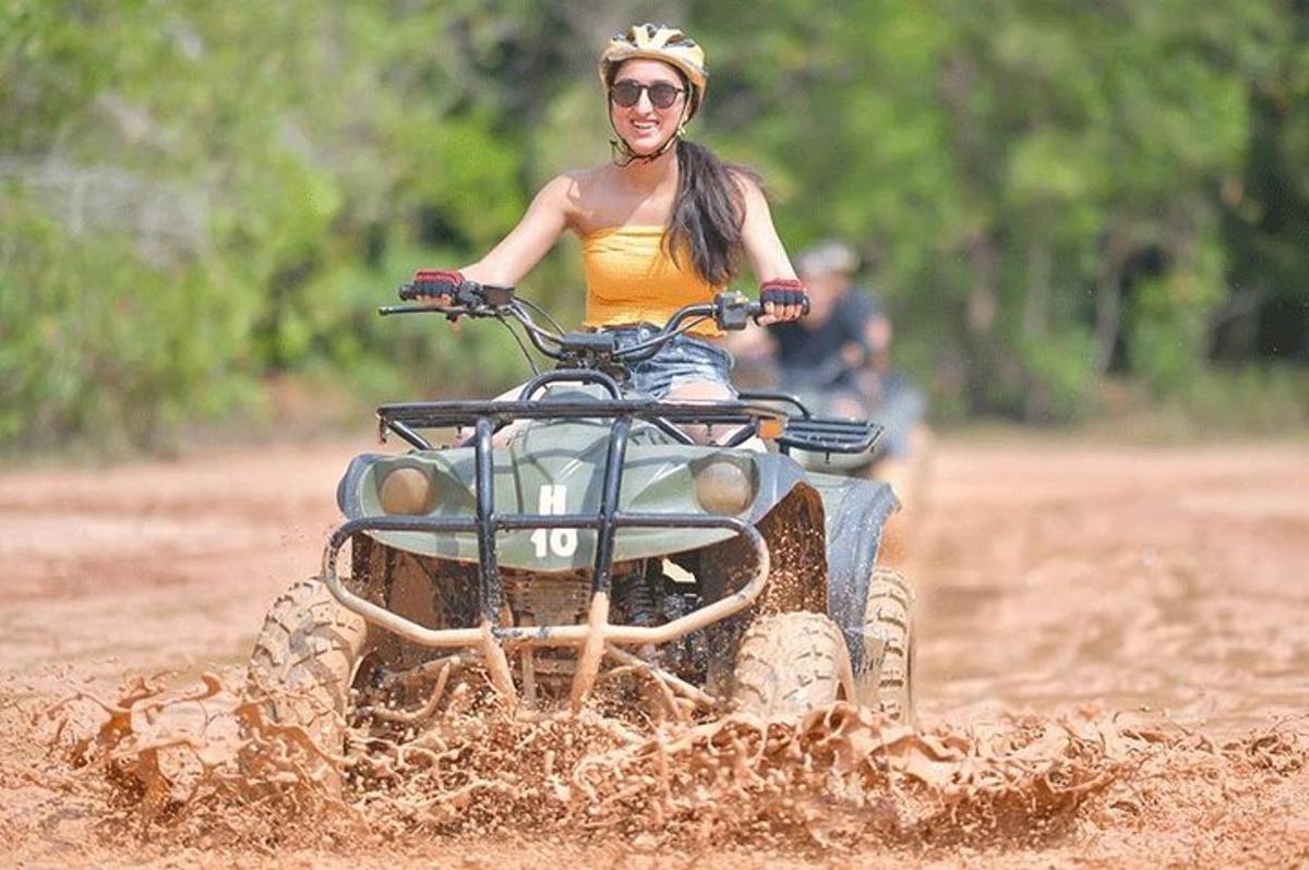 žena jedoucí na kolečkové kolečce blátem