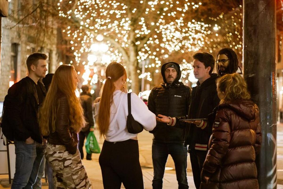 un gruppo di persone in piedi su una strada di notte
