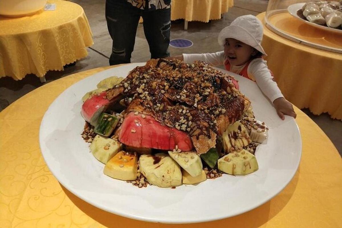 一个小女孩站在一盘食物前