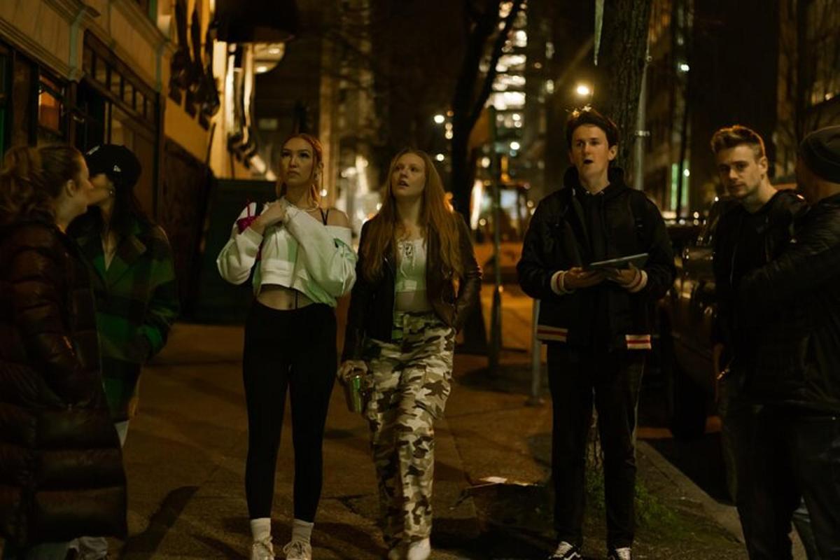 a group of people walking down a street at night