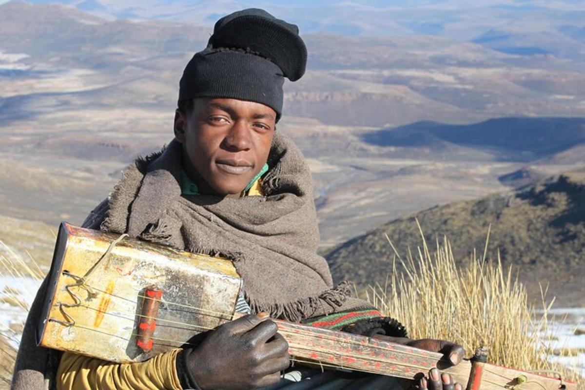 a man standing on top of a mountain holding a box