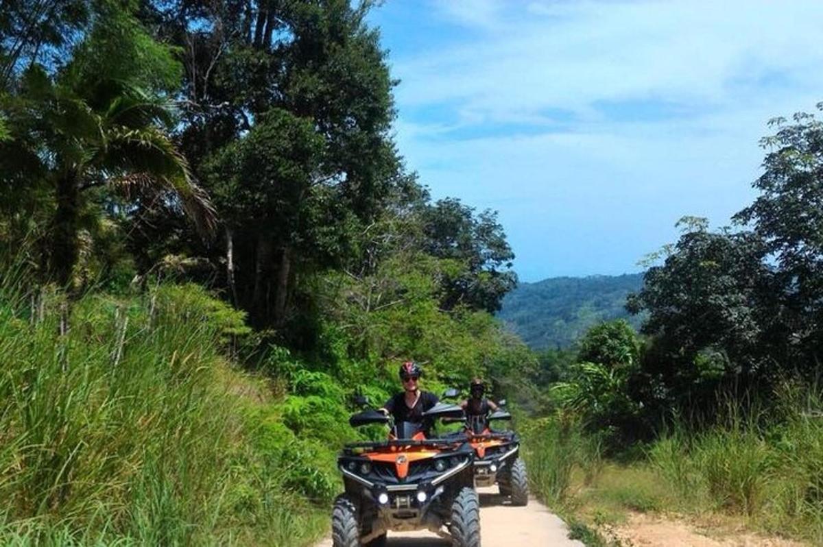 未舗装道路でATVに乗っている2人