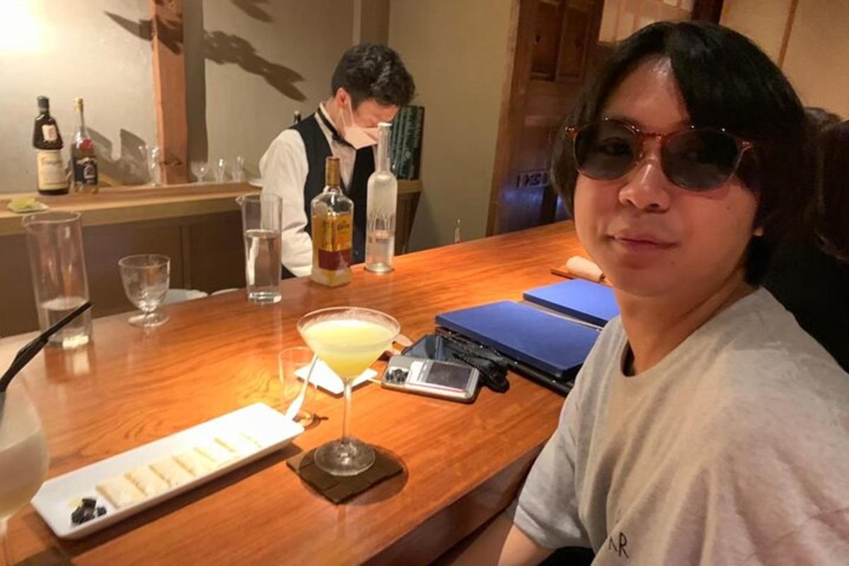 một người phụ nữ đang ngồi ở quầy bar với một ly đồ uống