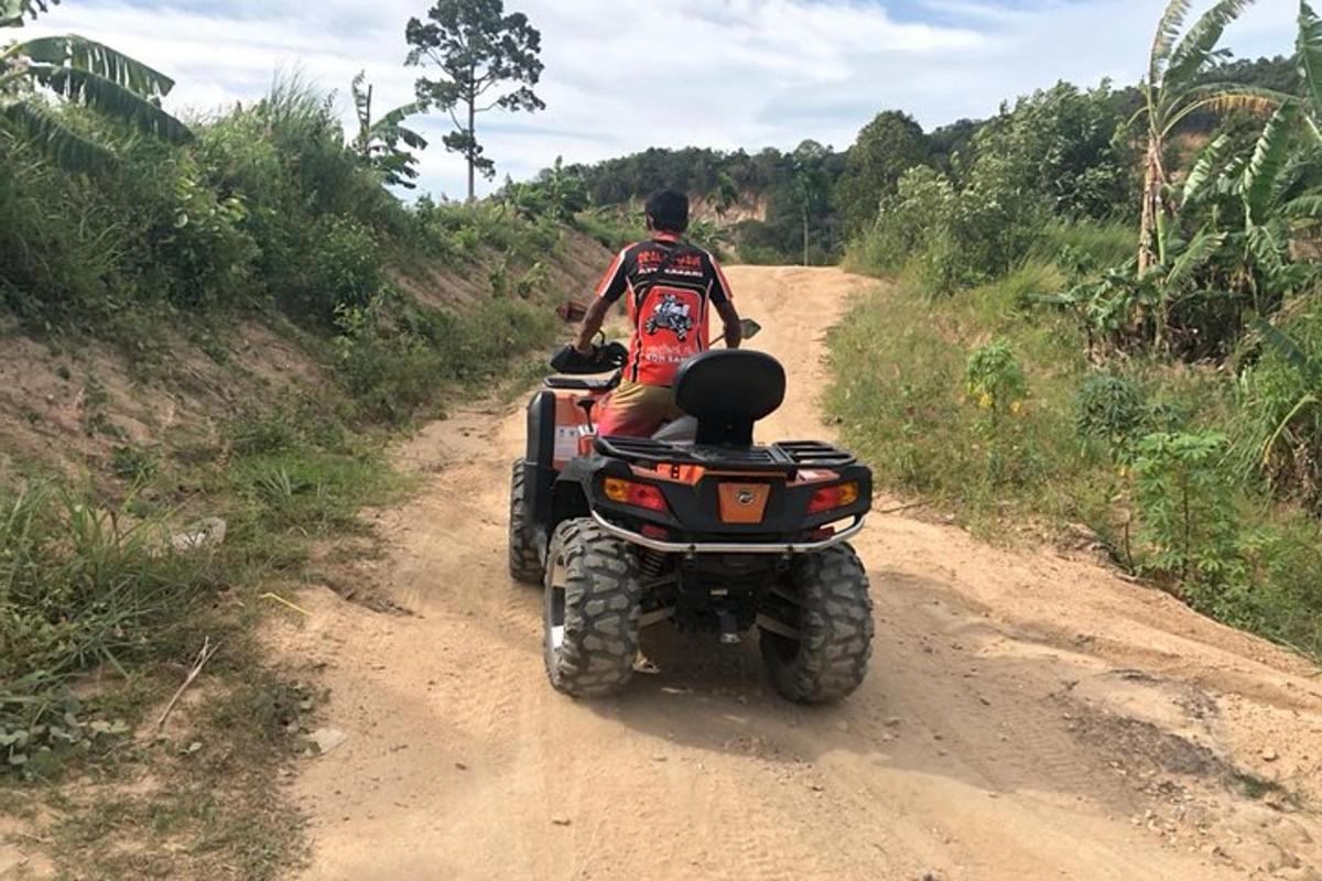 a man riding a quad bike on a dirt road