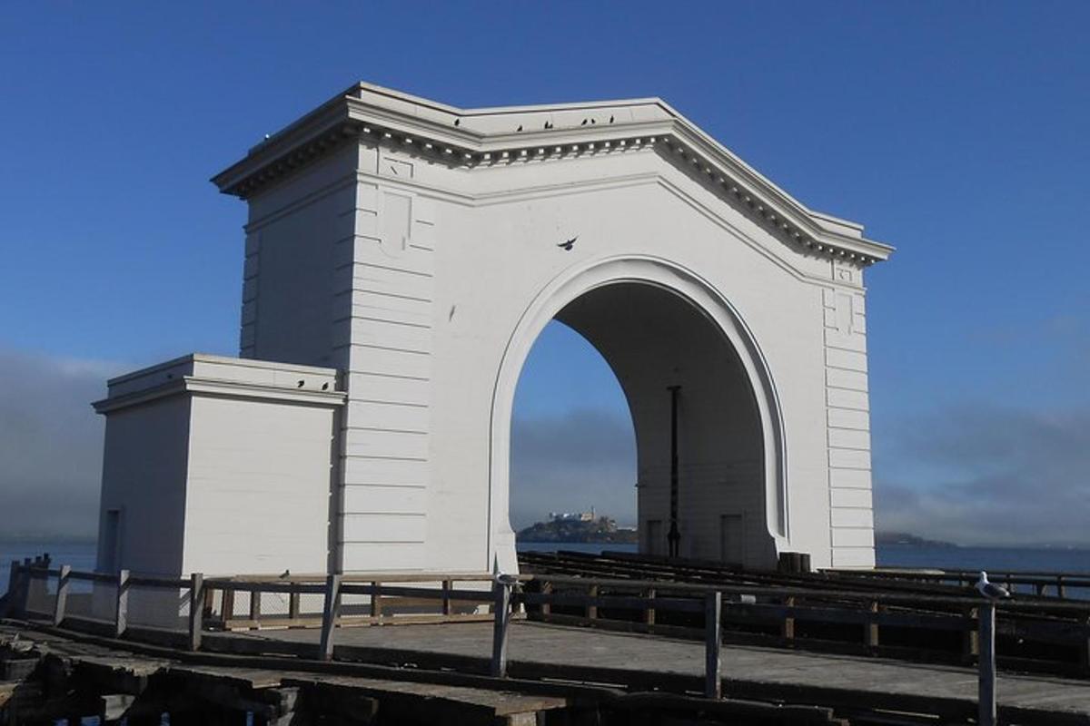 Un gran edificio blanco con un arco sobre el agua.