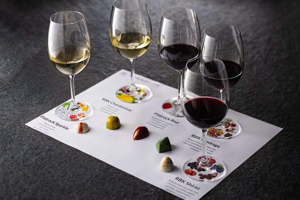 three glasses of wine and some food on a paper