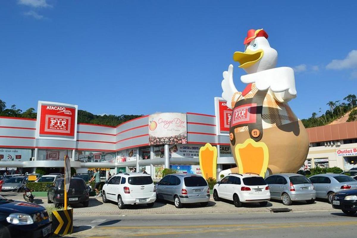 a large inflatable chicken in a parking lot in front of a store