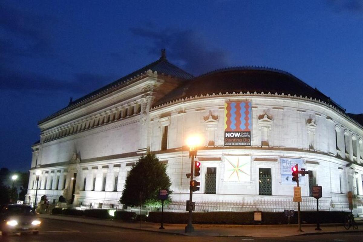 a large white building at night with a traffic light