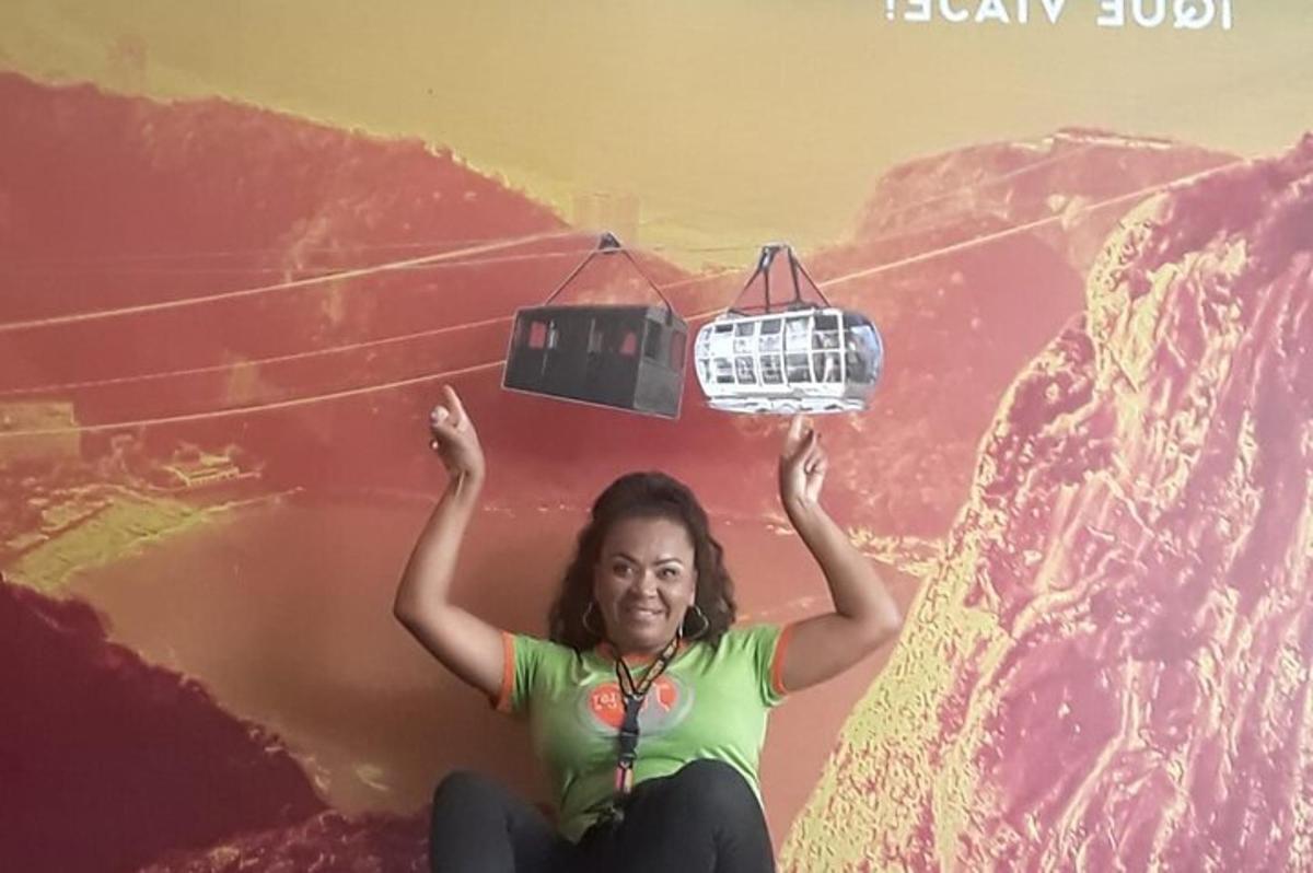 a woman sitting on top of a mountain with a cable car