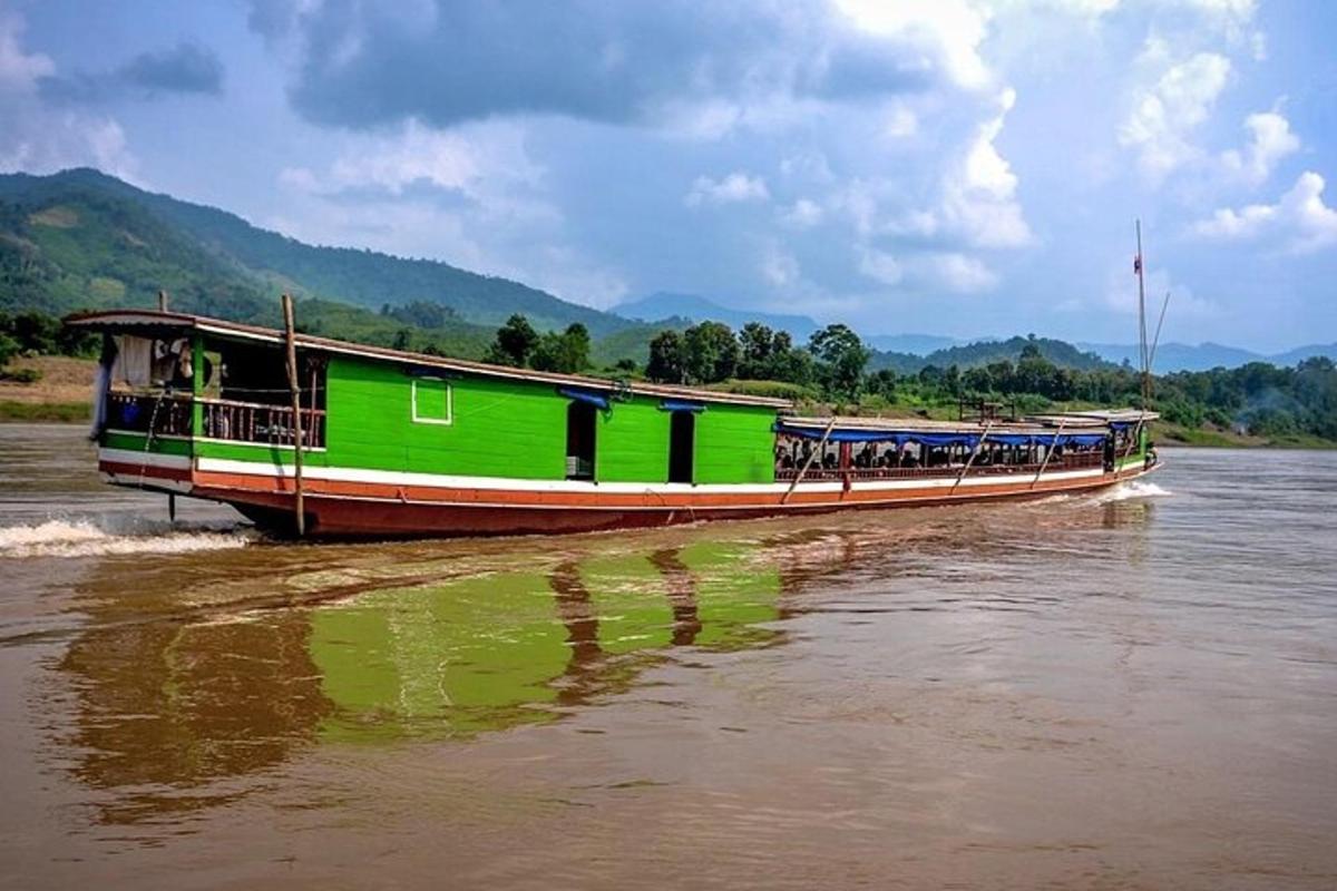 a green boat in the water on a river